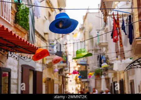 Bari, Italie - 22 septembre 2023 : chapeaux colorés comme lampes suspendues dans la vieille ville de Bari en Italie en été. Site touristique *** Bunte Hüte als Lampen hängen in der Altstadt von Bari in Italien im Sommer. Touristenattraktion Banque D'Images