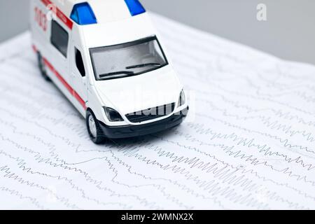 Ambulance, graphique EEG et stéthoscope sur fond gris gros plan Banque D'Images