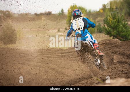 Moto cross - MX Girl motard à la course en Russie - un virage serré et le jet de saleté, vue arrière Banque D'Images