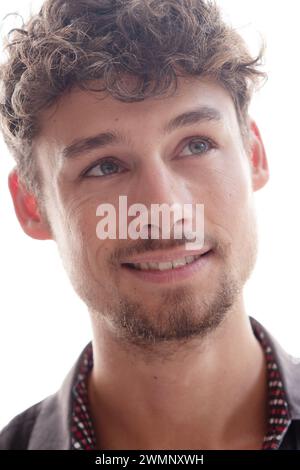Portrait en gros plan d'un jeune homme souriant regardant vers le haut et sur le côté Banque D'Images