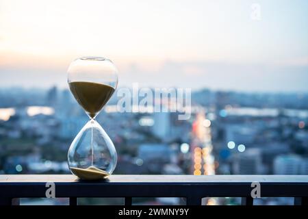 Un grand sablier sur un balcon de la ville donnant sur les gratte-ciel. Banque D'Images