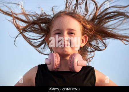 Jeune fille de 10 ans souriant comme les cheveux souffle dans le vent au coucher du soleil Lanzarote, îles Canaries, espagne Banque D'Images