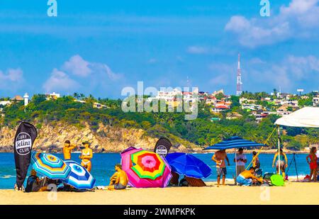 Puerto Escondido Oaxaca Mexique 13. Novembre 2022 Palm Trees personnes parasols parasols parasols et chaises longues au Beach Resort Hotel sur Tropical Mexican B Banque D'Images