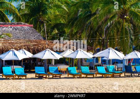 Puerto Escondido Oaxaca Mexique 13. Novembre 2022 Palm Trees personnes parasols parasols parasols et chaises longues au Beach Resort Hotel sur Tropical Mexican B Banque D'Images