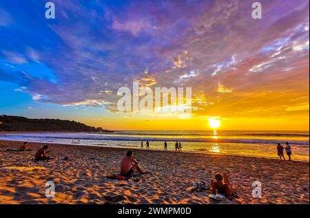 Les gens regardent le magnifique coucher de soleil coloré et doré en jaune Orange Rouge sur la plage et Big Wave Panorama dans la nature tropicale à Zicatela P. Banque D'Images