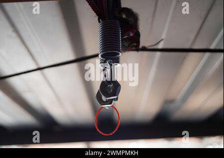 Vue rapprochée d'un ressort métallique et d'un clip attaché à un fil à l'intérieur Banque D'Images