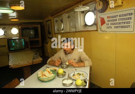 Pêcheurs d'usine d'Europe de l'est chalutier hommes connus sous le nom de Klondykers 1980s UK. Intérieur du bateau de pêche d'usine, pêcheur bulgare mangeant son déjeuner. 1986 Ullapool Écosse Royaume-Uni HOMER SYKES Banque D'Images