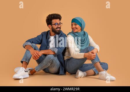Romantique jeune couple musulman assis sur le sol et regardant l'un l'autre Banque D'Images