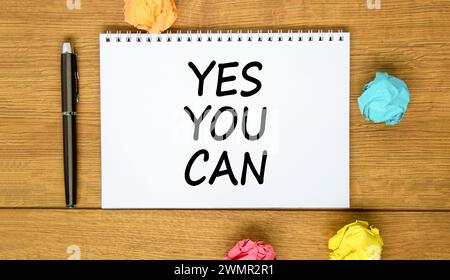 Motivation Oui vous pouvez symboliser. Mots conceptuels Oui vous pouvez sur une belle note blanche. Beau fond en bois. Stylo noir. Papier coloré. Mo. Affaires Banque D'Images