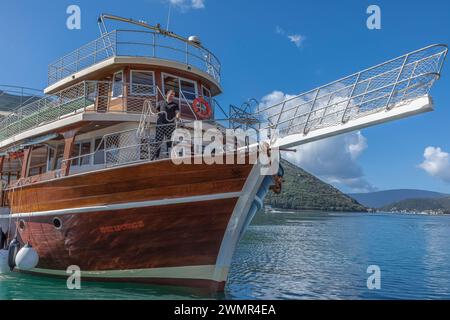 Baie de Koto, Monténégro - 25 avril 2022 - bateau amarrant sur la baie de Kotor comme un homme portant du noir lance une corde pour attacher le bpat Banque D'Images