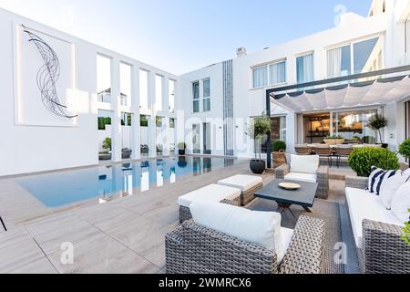 Une image d'arrière-cour dans un manoir méditerranéen de luxe d'une piscine à débordement et mobilier de jardin Banque D'Images