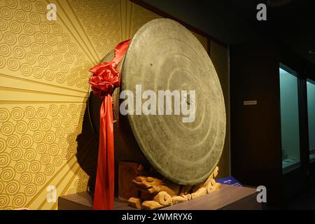 NANNING, CHINE - 27 FÉVRIER 2024 - les visiteurs regardent le plus grand tambour en bronze trouvé dans l'histoire archéologique du monde, un grand tambour en bronze avec un cl Banque D'Images