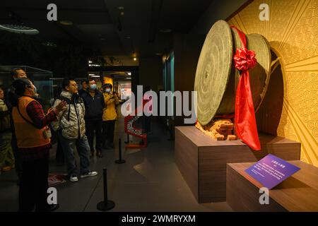 NANNING, CHINE - 27 FÉVRIER 2024 - les visiteurs regardent le plus grand tambour en bronze trouvé dans l'histoire archéologique du monde, un grand tambour en bronze avec un cl Banque D'Images