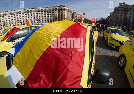 Bucarest, Roumanie - 27 février 2024 : plusieurs centaines de chauffeurs de taxi de tout le pays protestent devant le Parlement roumain contre les plateformes de covoiturage telles qu'UBER et Bold, exigeant la modification de la loi qui réglemente leur fonctionnement. Crédit : Lucian Alecu/Alamy Live Banque D'Images