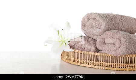 Serviettes fraîches et fleur de nénuphars sur une table en bois sur fond blanc. Espace pour le texte Banque D'Images