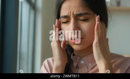 Gros plan malade fatigué femme arabe massage tempes souffrent de maux de tête douloureux migraine de la tête inconfort de pression. Fille indienne se sentent mal tension Banque D'Images