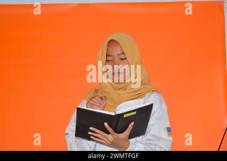 16 septembre 2023, photo d'une femme musulmane portant un livre, Wonosobo, Indonésie Banque D'Images