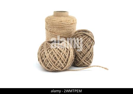 Trois bobines de ficelle de jute isolées sur fond blanc, chacune variant en taille, fabriquées à partir de matériaux naturels de jute Banque D'Images