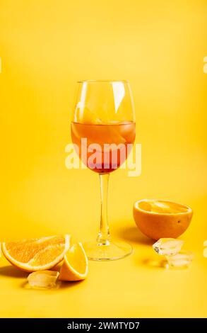 Cocktail Aperol spritz avec des oranges et de la glace sur fond jaune vif Banque D'Images