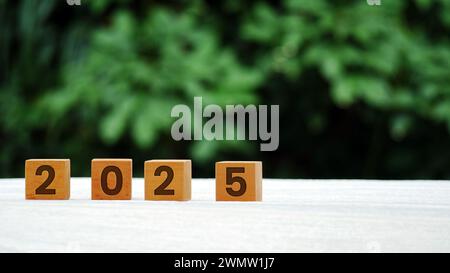 rond en bois avec des numéros sculptés 2025 sur une table en bois avec un fond flou. Banque D'Images