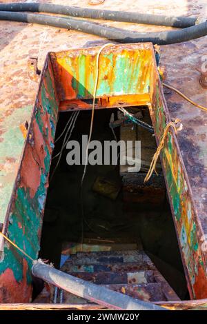 Passerelle endommagée avec échelle menant au pont inférieur d'un cargo écrasé, inondé d'eau, épave échouée à terre sur la plage d'Al Hamriyah aux Émirats arabes Unis. Banque D'Images