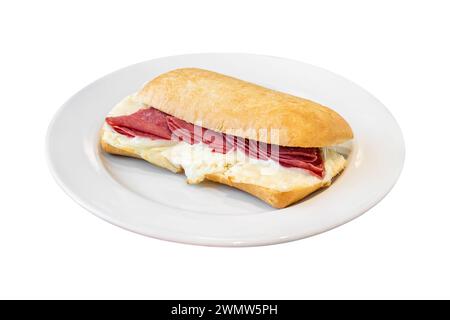 Sandwich au salami et au cheddar sur une assiette en porcelaine blanche sur une table en pierre Banque D'Images