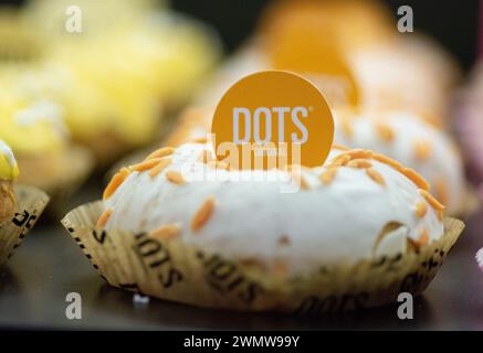 Beignets assortis avec garnitures colorées et messages imprimés sur fond de papier jaune Banque D'Images