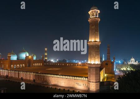Vue nocturne du paysage urbain sur l'ancienne mosquée Badshahi illuminée construite par l'empereur moghol Aurangzeb à l'extérieur du fort de Lahore, au Punjab, au Pakistan Banque D'Images