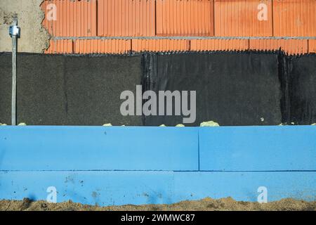 Mur de bâtiment extérieur avec des couches d'imperméabilisation et d'isolation thermique comme fond d'industrie de la construction Banque D'Images