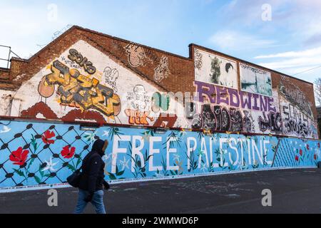 Londres, Royaume-Uni. 26 février 2024. Un membre du public passe de l'art de rue pro-palestinien sur un mur à Hackney Wick. Crédit : Mark Kerrison/Alamy Live News Banque D'Images