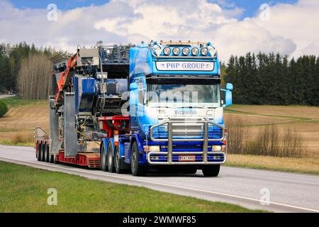 Personnalisé Scania 164 camion semi-remorque PHP Group Oy transporte l'équipement de concassage comme charge surdimensionnée le long de l'autoroute 52. Salo, Finlande. 13 mai 2022. Banque D'Images