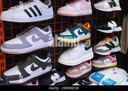 Voir l'affichage de beaucoup de chaussures de sport sur un mur. Vue sur un mur de chaussures à l'intérieur du magasin. Nouvelles chaussures de course à pied modernes et élégantes pour Homme et Homme Banque D'Images