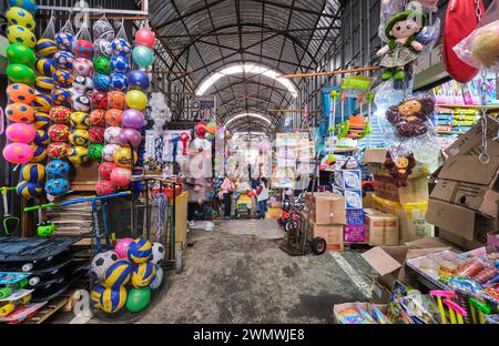 Une vue en bas d'un couloir typique, allée de nombreux magasins, magasins, vente de jouets. Au centre, une femme vend du thé dans un chariot. Au Barakholka Shipping co Banque D'Images