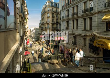 Paris, France - 17 février 2024 : vue des marches menant à une station de métro pittoresque et à un café typiquement français dans le quartier de Montmartre à Paris Banque D'Images