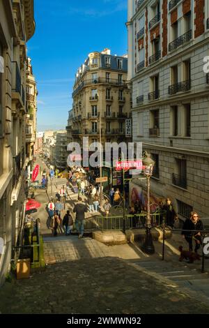 Paris, France - 17 février 2024 : vue des marches menant à une station de métro pittoresque et à un café typiquement français dans le quartier de Montmartre à Paris Banque D'Images