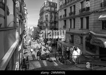 Paris, France - 17 février 2024 : vue des marches menant à une station de métro pittoresque et à un café typiquement français dans le quartier de Montmartre à Paris Banque D'Images