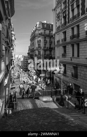 Paris, France - 17 février 2024 : vue des marches menant à une station de métro pittoresque et à un café typiquement français dans le quartier de Montmartre à Paris Banque D'Images