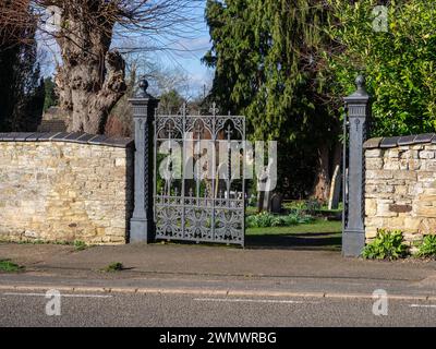 Portes en métal ornées noires pour le cimetière du village, Blisworth, Northamptonshire, Royaume-Uni Banque D'Images