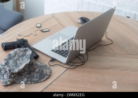 armes d'uniforme militaire et ordinateur portable sur la table Banque D'Images