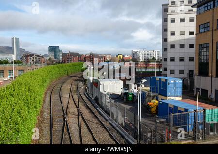 Comté de Belfast Antrim Irlande du Nord 23 février 2024 - voies ferrées menant à la gare de Lanyon place avec la ligne d'horizon de la ville derrière Banque D'Images