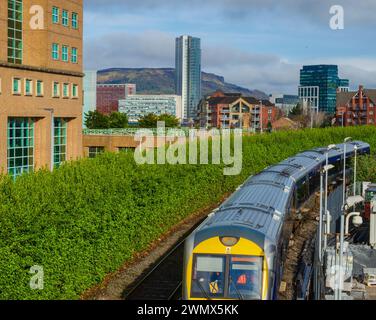 Belfast County Antrim Irlande du Nord 23 février 2024 - train entrant dans la gare de Lanyon place avec la ligne d'horizon de la ville derrière Banque D'Images