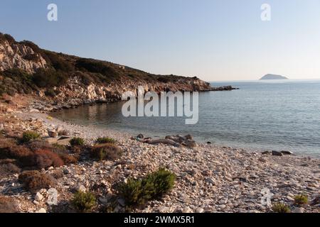 Description : niché le long de la côte de l'île de Fourni se trouve un joyau caché : une plage rocheuse, mais incroyablement belle, tranquille. Sculpté par le reliquaire Banque D'Images