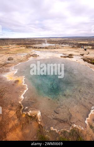 Les touristes regardent l'éruption du Grand Geysir en Islande Banque D'Images