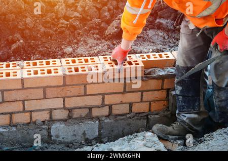 Briques de maçonnerie industrielles sur le mélange de ciment sur le chantier. Combattre la crise du logement en construisant des maisons plus abordables concept Banque D'Images