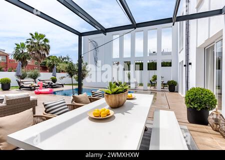 une image de jardin donnant sur une table à manger extérieure et une piscine à débordement dans un manoir méditerranéen de luxe Banque D'Images