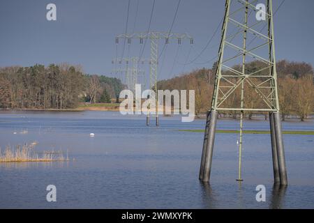 Wittenberge, Allemagne. 28 février 2024. Des pylônes électriques se dressent dans l'eau sur une prairie inondée près des limites de la ville. Crédit : Soeren Stache/dpa/Alamy Live News Banque D'Images