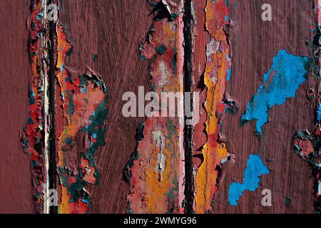 Plan macro d'une surface en bois altérée avec des couches de peinture écaillée de différentes couleurs Banque D'Images
