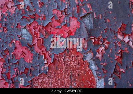Photographie macro montrant la texture détaillée de la peinture rouge fissurée et écaillée sur une surface métallique Banque D'Images