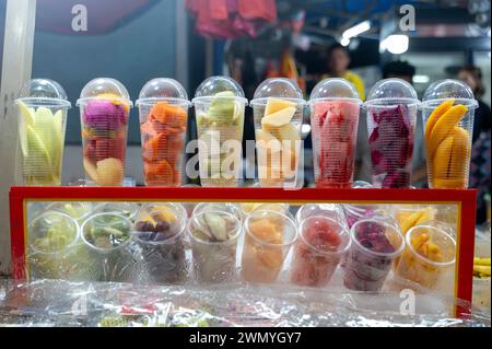 Des coupes de fruits fraîchement coupées sont exposées sur un marché malaisien, mettant en vedette des produits tropicaux dynamiques. Banque D'Images