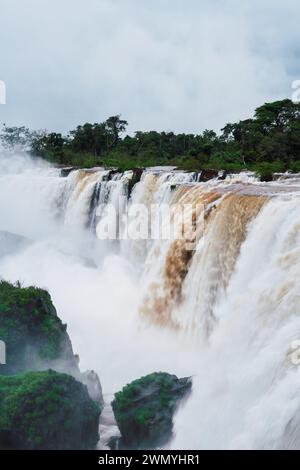La brume s'élève des puissantes chutes d'Iguazu entourées d'une forêt verdoyante à la frontière de l'Argentine et du Brésil. Banque D'Images